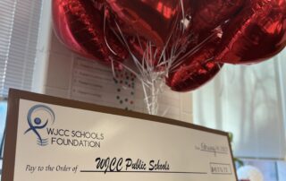 Large check on an easel with balloons